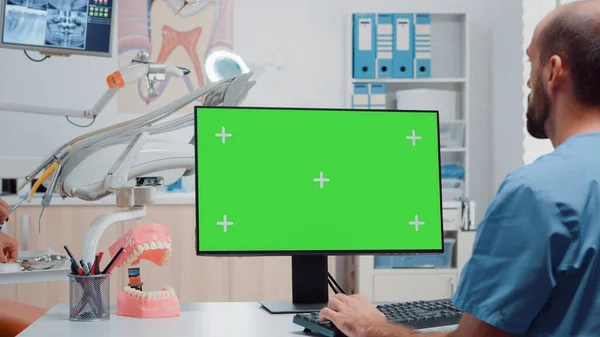 Infermiera uomo guardando schermo verde orizzontale sul monitor — Foto Stock
