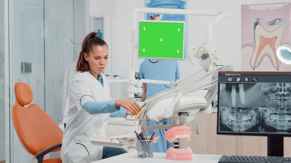 Vrouw met horizontaal groen scherm op monitor — Stockfoto