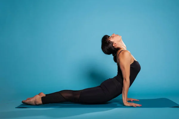 Fitness donna seduta su tappetino yoga in posa backbend cane che si estende indietro — Foto Stock