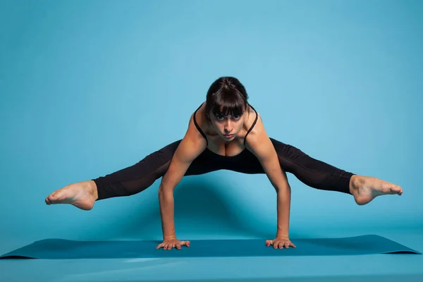 Atleta persona in piedi in mani su tappetino yoga stretching muscoli del corpo — Foto Stock