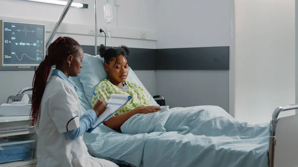 Team van Afro-Amerikaanse artsen consulteren patiënt in bed — Stockfoto