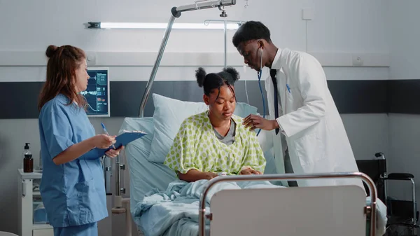 Afro-Amerikaanse arts met stethoscoop op zieke patiënt — Stockfoto