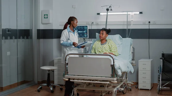 African american doctor doing consultation with patient in bed — Stock Photo, Image