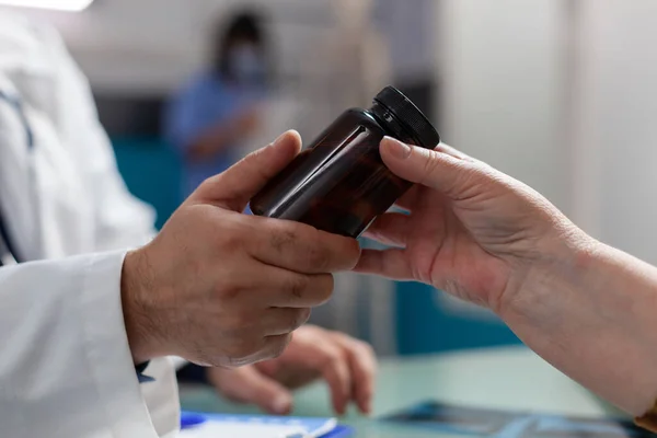 オフィスで薬の瓶を保持医師やシニア女性の手 — ストック写真