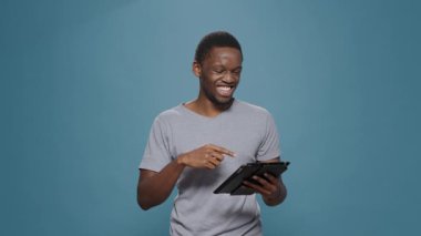 Genç yetişkin dijital tablette sosyal medya uygulamasına gülüyor