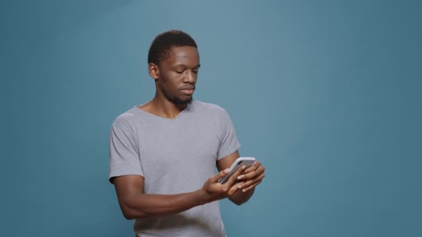 Hombre alegre leyendo buenas noticias y logros en el teléfono inteligente — Vídeo de stock