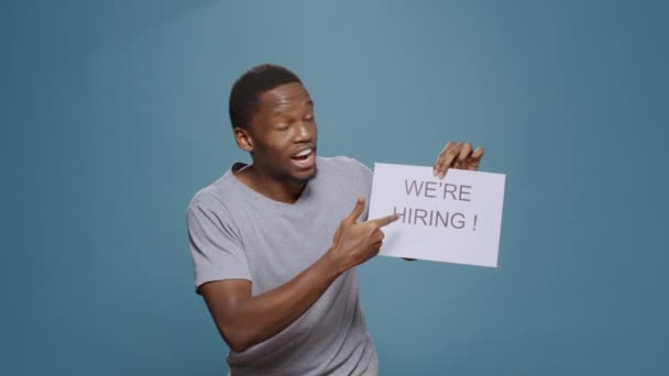 Employé de l'entreprise montrant le signe de demande d'embauche sur papier — Video