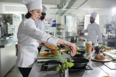 Yemek endüstrisi çalışanı tavada köfte pişirirken restorandaki güzel yemek servisine lezzetli yemekler hazırlıyor..