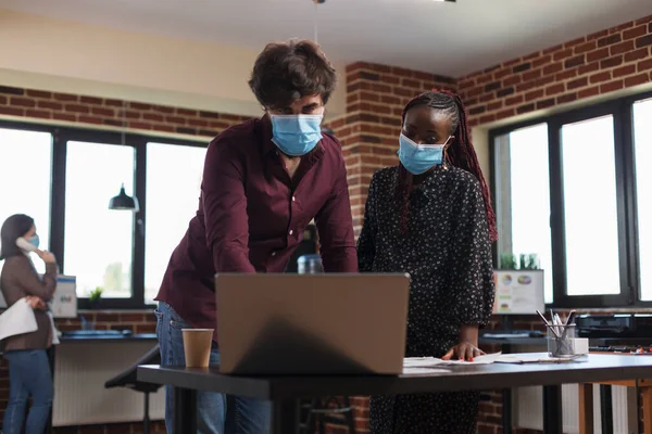 Coronavirus 'a karşı maske takan çok çeşitli etnik ofis çalışanları şirket muhasebe verilerini analiz ediyorlar. — Stok fotoğraf