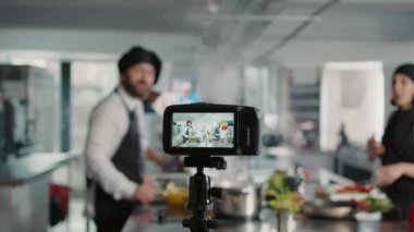 Profesyonel menü yemeği pişiren insanları filme alan kamera.