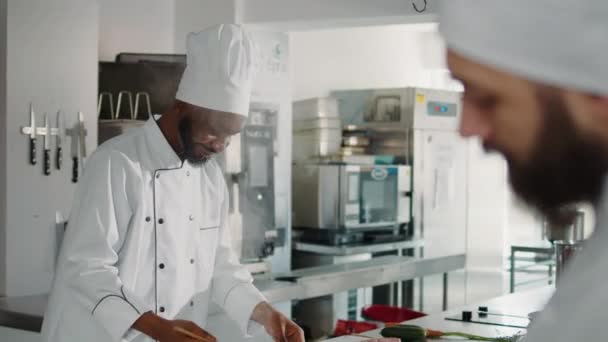 Homem afro-americano gosto testando sopa de legumes no fogão — Vídeo de Stock