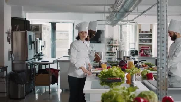 Портрет уверенной женщины со скрещенными руками на занятой кухне — стоковое видео