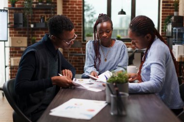 Yönetim departmanı çalışanları muhasebe belgelerini analiz ediyor.