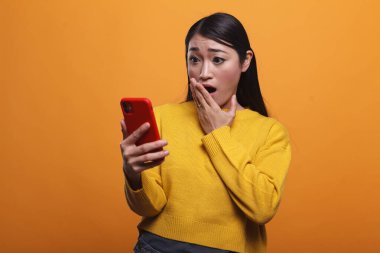 Şok olmuş bir kadın modern akıllı telefondan trajik haberler izleyerek nutku tutuldu..