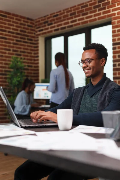 Homme d'affaires afro-américain souriant développant une stratégie de marketing de démarrage et un plan publicitaire. — Photo