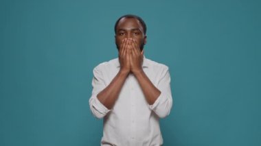 Sessiz kalmak için gözleri, ağzı ve kulakları kaplayan genç bir yetişkin.