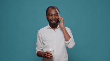 Kahve fincanı taşıyan sıradan bir girişimci telefonla konuşuyor.