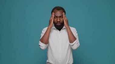 Stüdyoda baş ağrısından muzdarip yorgun hasta bir adam.