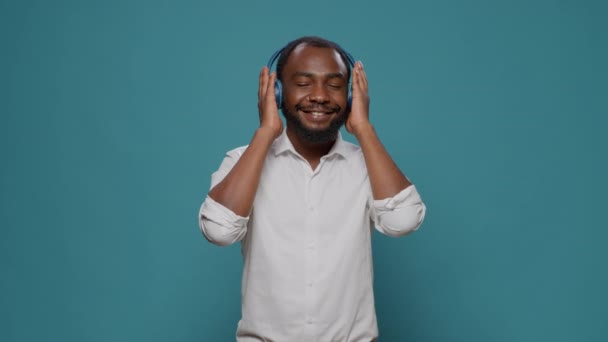 Χαμογελαστός ενήλικας χρησιμοποιώντας ακουστικά για να ακούσετε μουσική mp3 ραδιόφωνο — Αρχείο Βίντεο