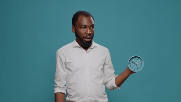 Uomo d'affari in stato di shock guardando il tempo su orologio da parete in studio — Video Stock