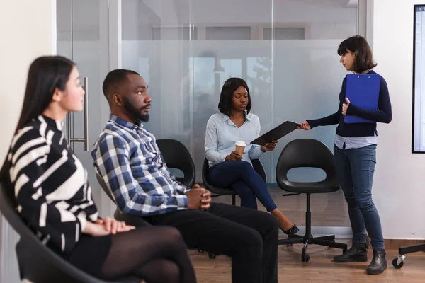 Kierownik działu HR daje afrykańskiej amerykance formularz podania o pracę, czekając w holu firmy marketingowej. — Zdjęcie stockowe