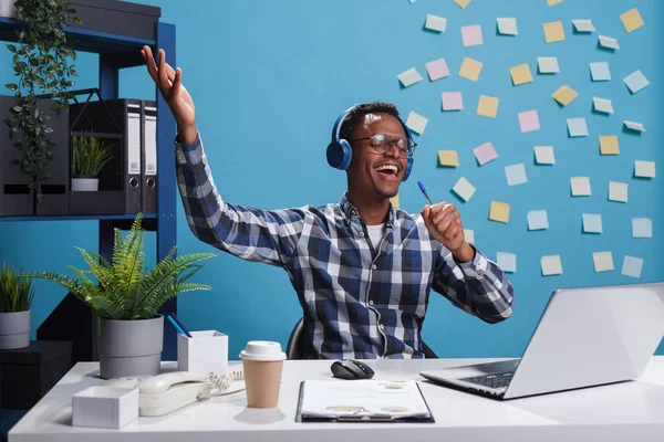 Alegre sorrindo carinhosamente jovem trabalhador de escritório usando fones de ouvido sem fio — Fotografia de Stock