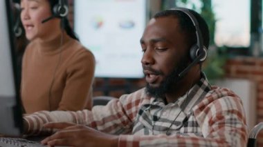 Müşteri hizmetlerindeki tele-iş çağrılarına cevap veren genç adam.