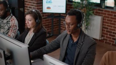 Çağrı merkezinde çalışan Afrikalı Amerikalı erkek ve beyaz kadın.