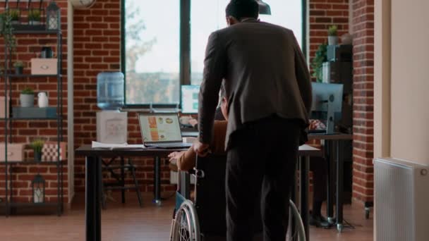 Αφροαμερικάνος άνδρας που βοηθά γυναίκα σε αναπηρικό καροτσάκι με μεταφορά — Αρχείο Βίντεο