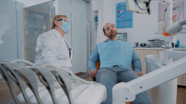 Diş röntgencisine bakan ortodontist monitörde