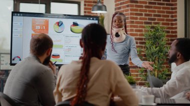 Boyun tasması takmış yaralı bir kadın iş üzerinde çalışıyor.