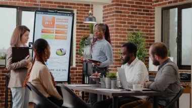 Ekranda analiz çizelgeleri sunan çok ırklı meslektaşlar