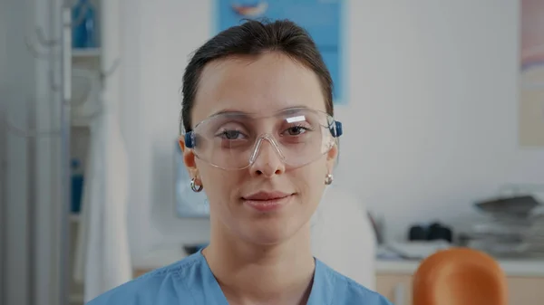 Retrato de assistente com óculos de proteção na clínica de cuidados bucais — Fotografia de Stock