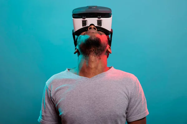 Ανδρικό μοντέλο κοιτάζει ψηλά ενώ χρησιμοποιεί γυαλιά εικονικής πραγματικότητας — Φωτογραφία Αρχείου