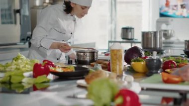 Otantik aşçı, kötü sosu mutfak sobasında test ediyor.