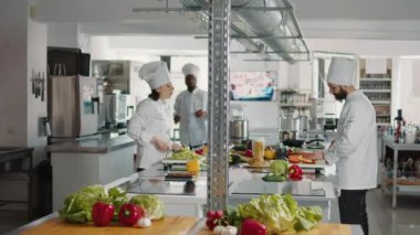 Bir grup aşçı kesim tahtasında sebze doğruyor.