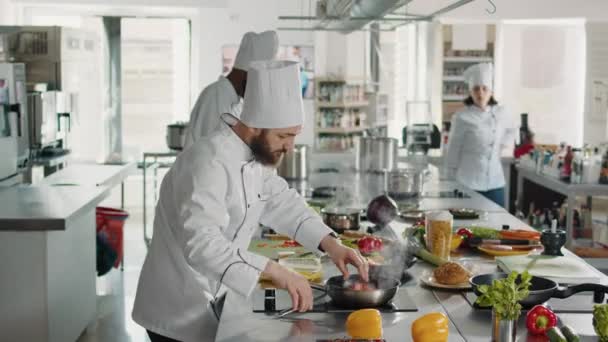 Професійний шеф-кухар додає тертий пармезан на їжу в сковороді — стокове відео