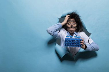 Kirli suratlı ve şapşal suratlı çılgın bilim adamı örneklerle dolu duruyor..