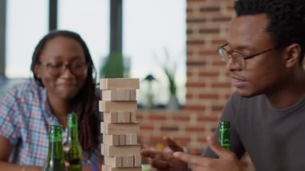 Grupo de pessoas alegres se divertindo com a torre de madeira de jenga — Vídeo de Stock