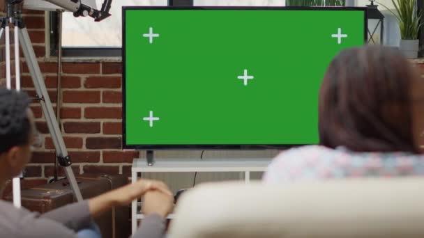 Män och kvinnor tittar på tv-skärm med grön skärm — Stockvideo