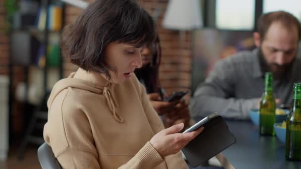 Kobieta przeglądająca internet przez telefon komórkowy podczas zabawy — Wideo stockowe