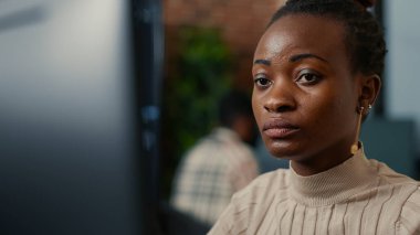 African american software programer working focused looking at computer screen and smiling while typing