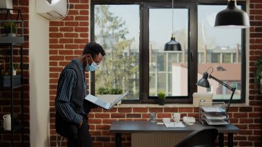 Ofiste dizüstü bilgisayarla dolaşan endişeli işçiler.