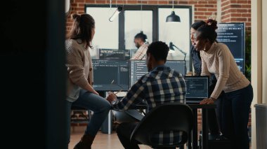 Software programmers discussing about online cloud computing while the rest of the team joins