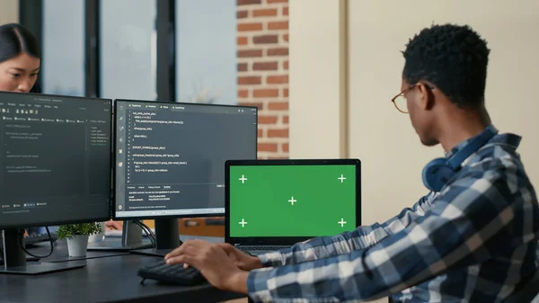 Software developer writing code using computer keyboard and laptop with green screen chroma key mockup — Fotografia de Stock