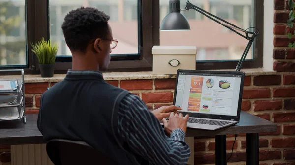 Dipendente che utilizza il computer portatile per pianificare gli investimenti nella carriera in ufficio startup — Foto Stock