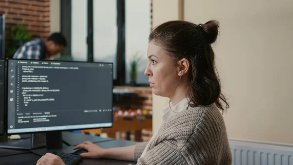 Retrato del ingeniero de software enfocado escribiendo código mirando múltiples pantallas de computadora —  Fotos de Stock