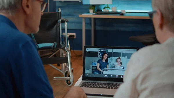 Morföräldrar pratar med familj på sjukhus på online-konferens — Stockfoto