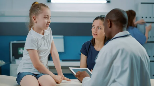 Pequena criança tendo discussão com o médico masculino no exame — Fotografia de Stock