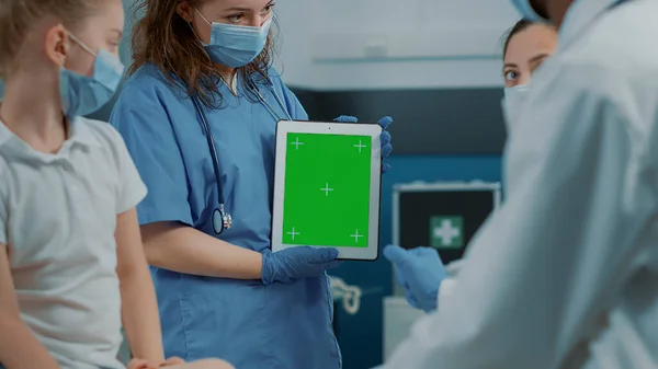 Enfermeira segurando tablet digital com fundo de tela verde — Fotografia de Stock